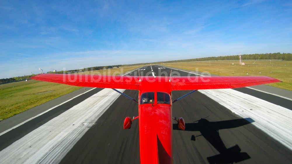 Berlin von oben - Rote Cessna beim Tiefanflug über die Piste 26R am Flughafen Tegel in Berlin, Deutschland