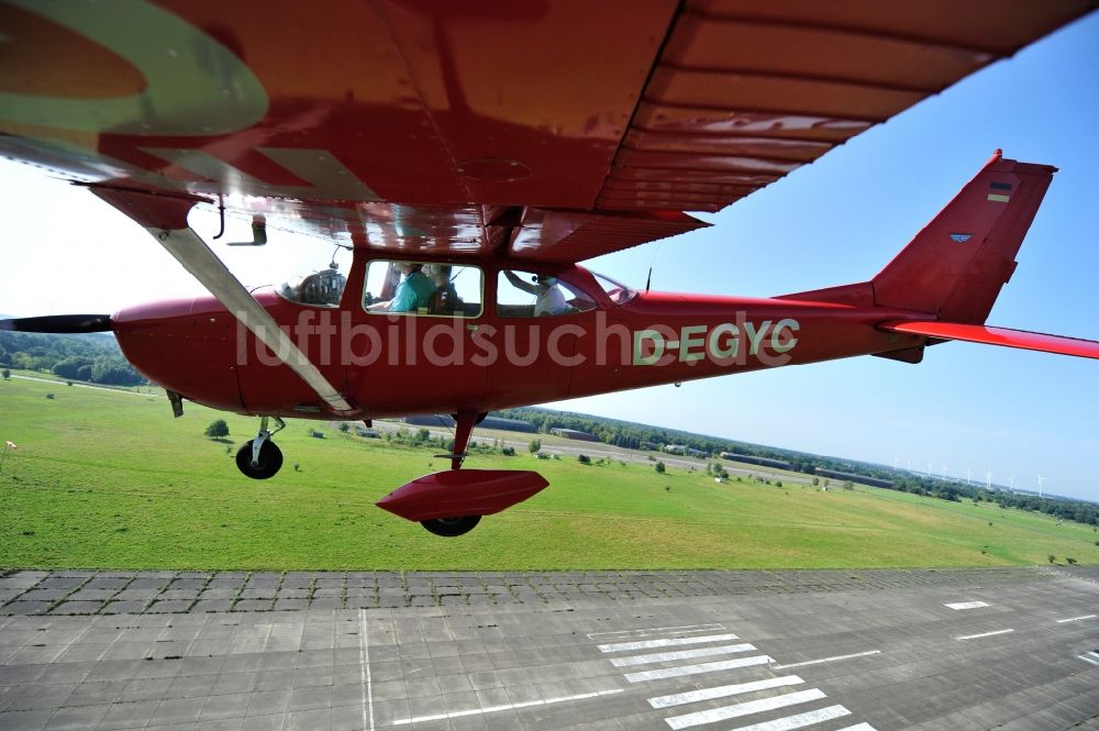 Werneuchen aus der Vogelperspektive: Rote Cessna 172 D-EGYC der Agentur euroluftbild.de im Flug über den Flugplatz in Werneuchen im Bundesland Brandenburg, Deutschland