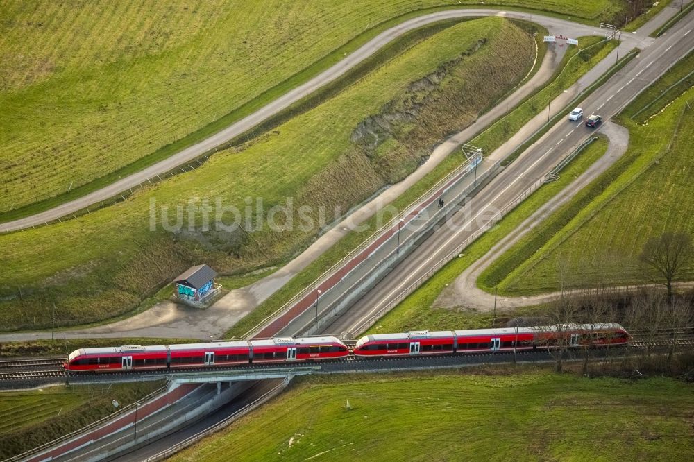 Hamm aus der Vogelperspektive: Roter Regionalzug der Bahn überquert eine Straßenunterführung bei Bockum-Hövel in Hamm im Bundesland Nordrhein-Westfalen