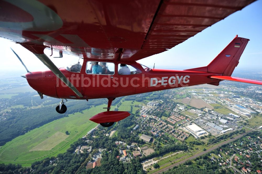 Luftaufnahme Hoppegarten - Rotes Flugzeug Cessna F172H mit der Kennung D-EGYC im Fluge über dem Luftraum im Ortsteil Dahlwitz-Hoppegarten in Hoppegarten im Bundesland Brandenburg, Deutschland