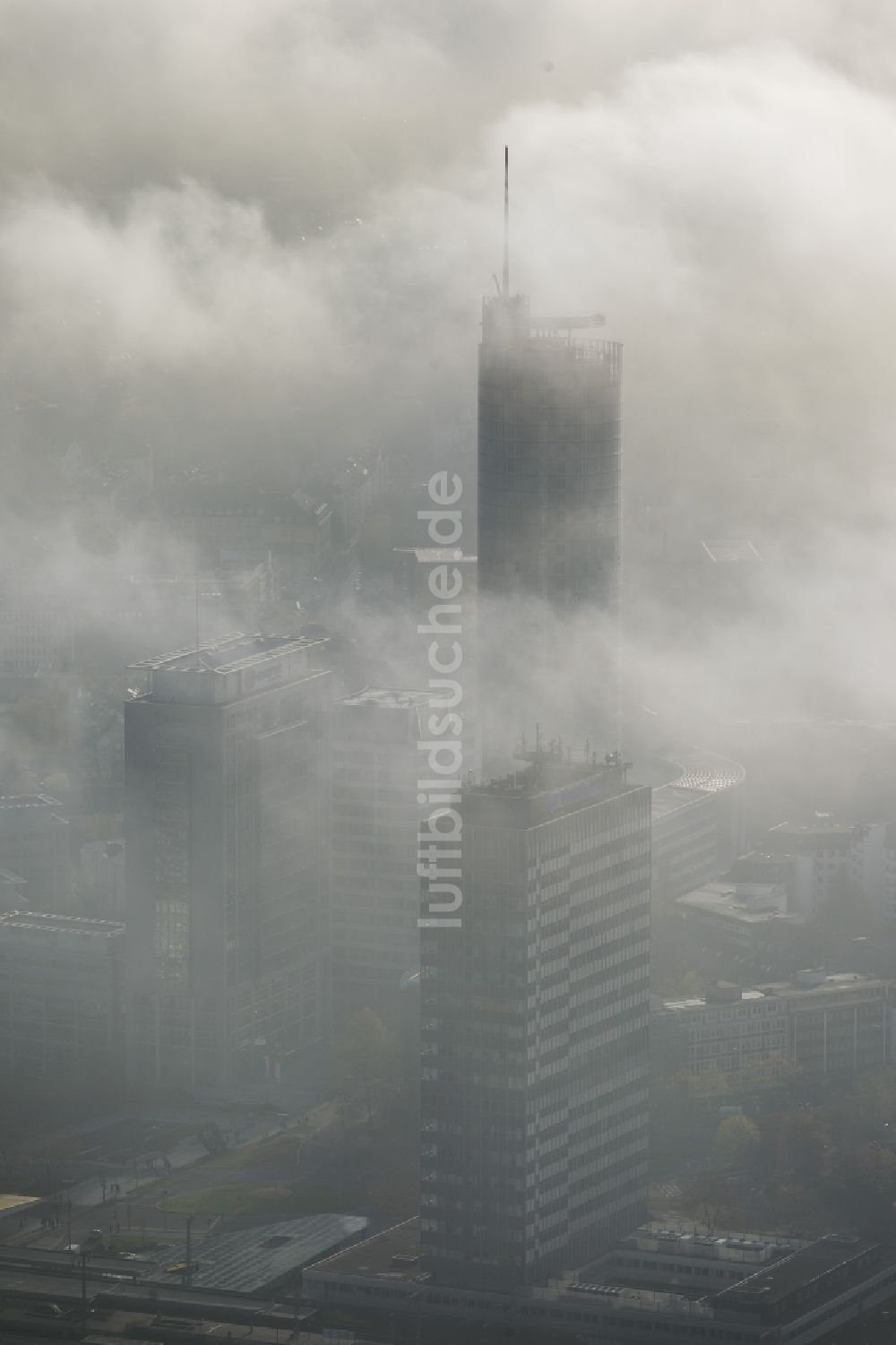 Luftbild Essen - RWE- Turm Essen umhüllt von Nebel und einer einer imposanten Wolkenwand über der Skyline der Essener Innenstadt im Bundesland Nordrhein-Westfalen