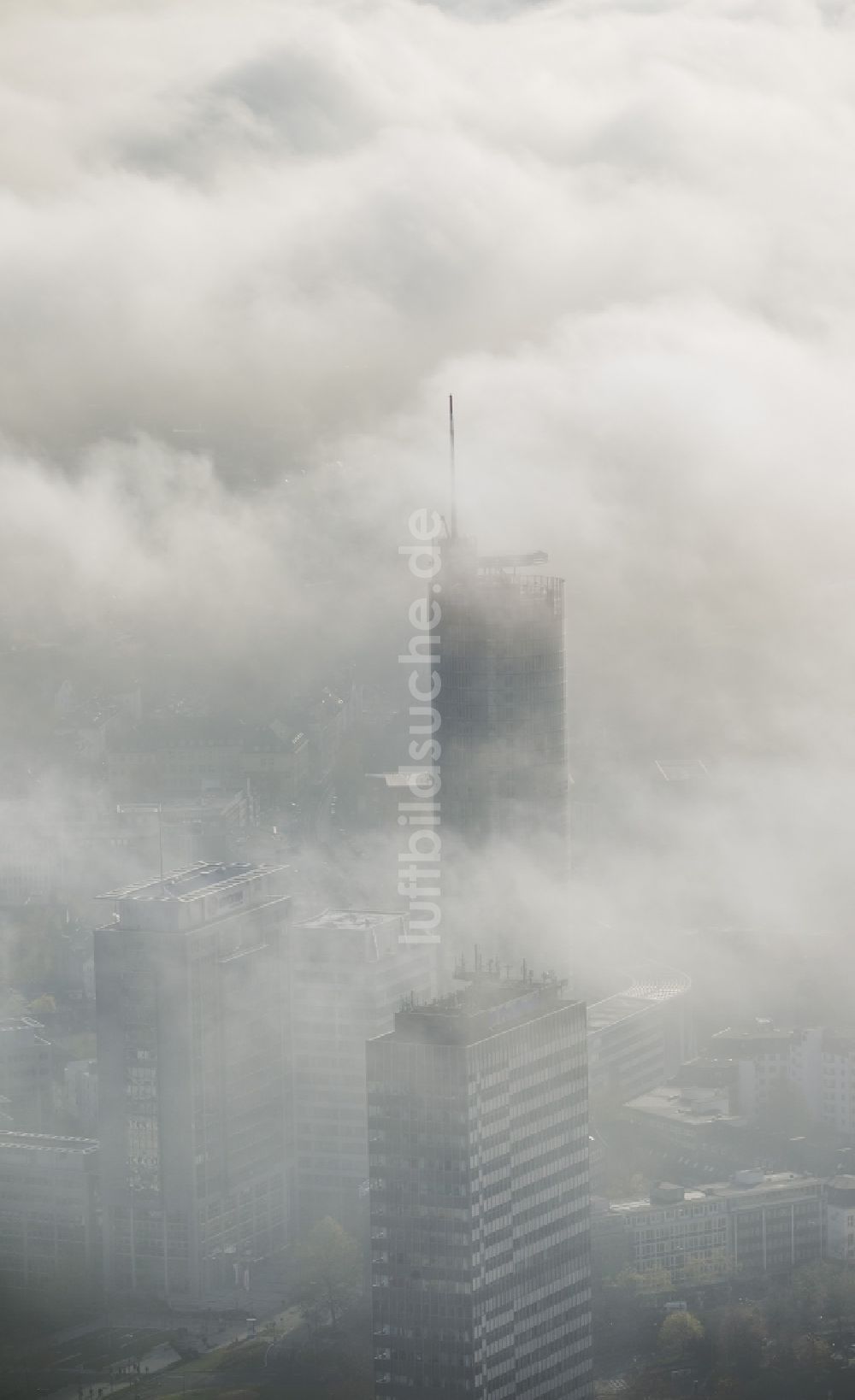 Luftaufnahme Essen - RWE- Turm Essen umhüllt von Nebel und einer einer imposanten Wolkenwand über der Skyline der Essener Innenstadt im Bundesland Nordrhein-Westfalen