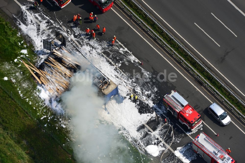 Hollenstedt von oben - Schaumteppich- Löscharbeiten der Feuerwehr bei einem LKW- Lastkraftwagen- Brand- Feuer auf der BAB Autobahn A1 - E22 bei Hollenstedt im Bundesland Niedersachsen