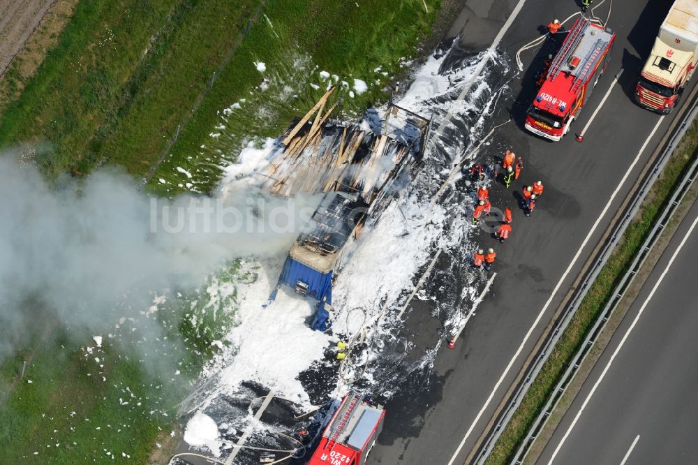 Luftaufnahme Hollenstedt - Schaumteppich- Löscharbeiten der Feuerwehr bei einem LKW- Lastkraftwagen- Brand- Feuer auf der BAB Autobahn A1 - E22 bei Hollenstedt im Bundesland Niedersachsen