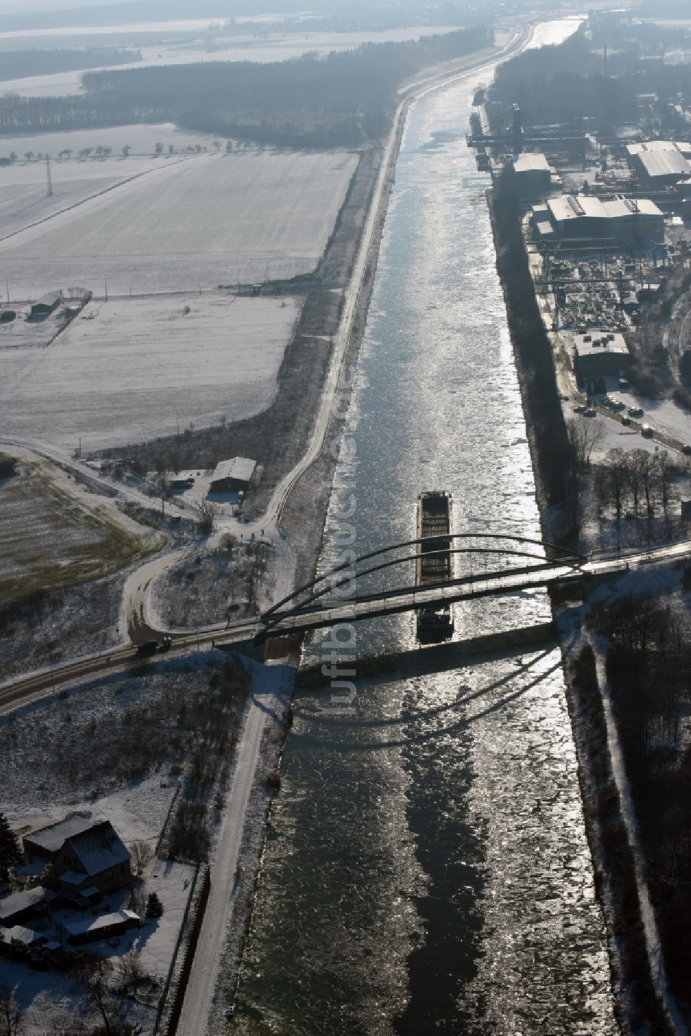 Luftaufnahme Parey - Schiff und Schubverband der Binnenschiffahrt in Fahrt auf der winterlich mit Schnee und Eis bedeckten Flußverlaufes des Elbe-Havel-Kanal in Parey im Bundesland Sachsen-Anhalt