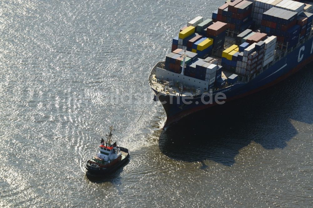 Hamburg aus der Vogelperspektive: Schlepper vor dem Containerschiff - Frachter CMA CGM MAUPASSANT einer britischen Reederei bei der Fahrt in den Hafenbereich auf dem Elbstrom in Hamburg