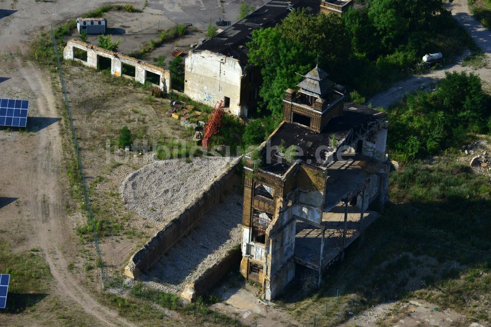 Muldenstein aus der Vogelperspektive: Solarfelder mit Photovoltaikanlagen am Solarkraftwerk an der Fassaden- Ruine des alten Rohrwerkes Muldenstein im Bundesland Sachsen-Anhalt