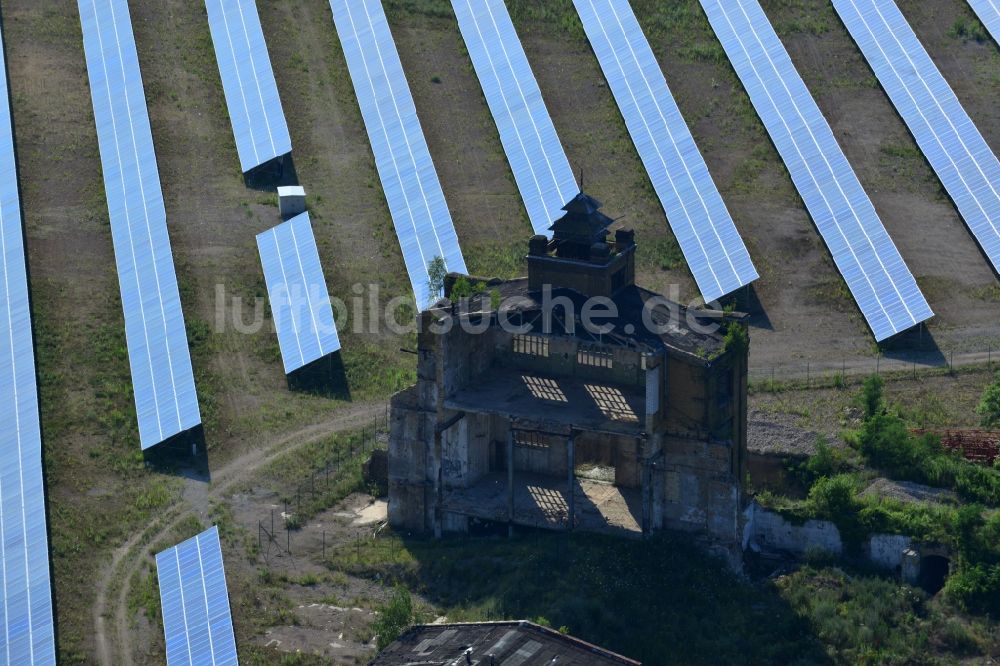 Muldenstein aus der Vogelperspektive: Solarfelder mit Photovoltaikanlagen am Solarkraftwerk an der Fassaden- Ruine des alten Rohrwerkes Muldenstein im Bundesland Sachsen-Anhalt