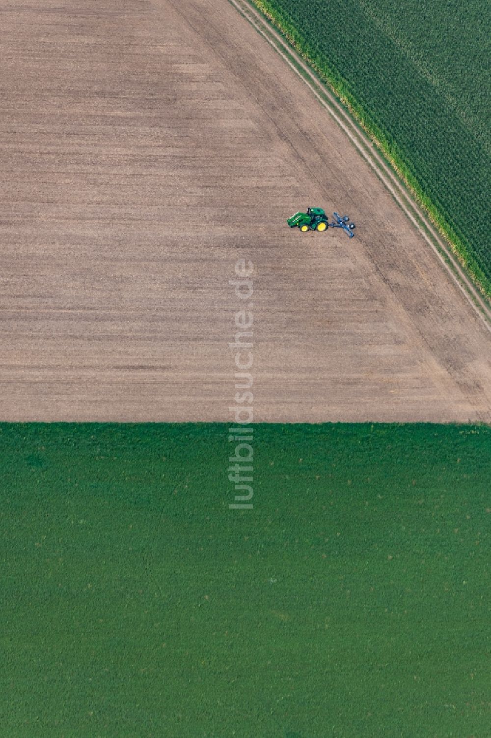 Luftaufnahme Pliening - Umpflugarbeiten und Umschichtung der Erde durch einen Traktor mit Pflug auf landwirtschaftlichen Feldern in Pliening im Bundesland Bayern, Deutschland