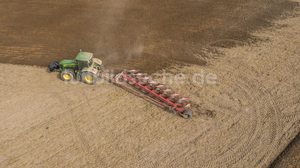 Luftaufnahme Sauheim - Umpflugarbeiten und Umschichtung der Erde durch einen Traktor mit Pflug auf landwirtschaftlichen Feldern in Sauheim im Bundesland Bayern