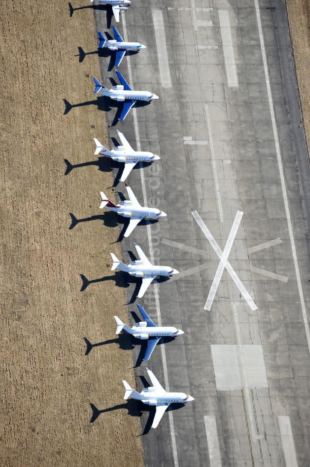 Schönefeld aus der Vogelperspektive: Verkehrsflugzeuge und Jets der Allgemeinen Luftfahrt auf dem Reststreifen der alten Start- und Landebahn am Flughafen Berlin-Schönefeld