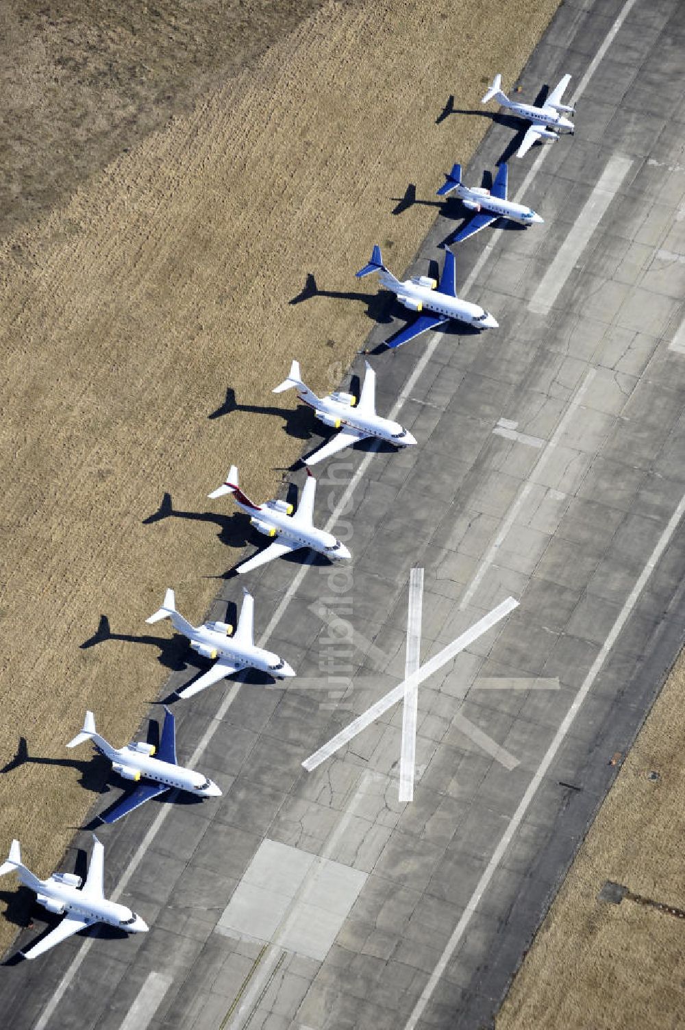 Schönefeld aus der Vogelperspektive: Verkehrsflugzeuge und Jets der Allgemeinen Luftfahrt auf dem Reststreifen der alten Start- und Landebahn am Flughafen Berlin-Schönefeld