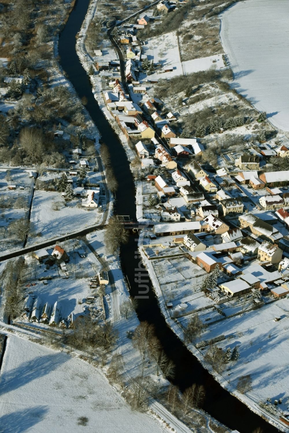 Niederfinow aus der Vogelperspektive: Verlauf des Flusses Alte Finow entlang des Ortsrandes des winterlich verschneiten Dorfes Niederfinow im Bundesland Brandenburg