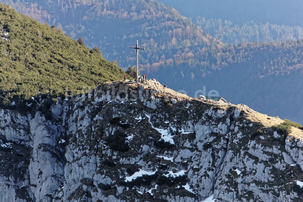 Benediktbeuern von oben - Wanderer auf dem Westgipfel mit Gipfelkreuz der Benediktenwand bei Benediktbeuern im Bundesland Bayern