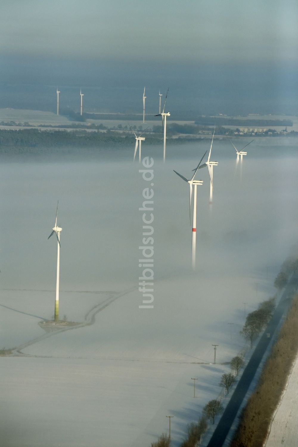 Luftbild Werneuchen - Windkraftanlagen - Windrad- auf einem nebelbedeckten und schneebedeckten winterlichen Feld in Werneuchen im Bundesland Brandenburg