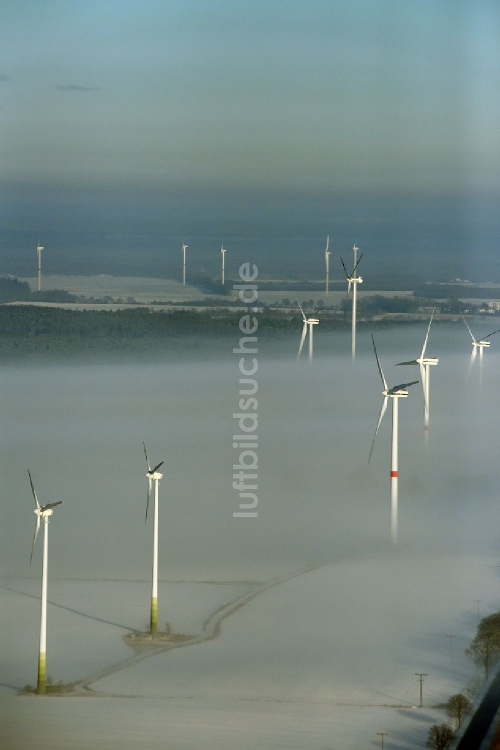 Luftaufnahme Werneuchen - Windkraftanlagen - Windrad- auf einem nebelbedeckten und schneebedeckten winterlichen Feld in Werneuchen im Bundesland Brandenburg