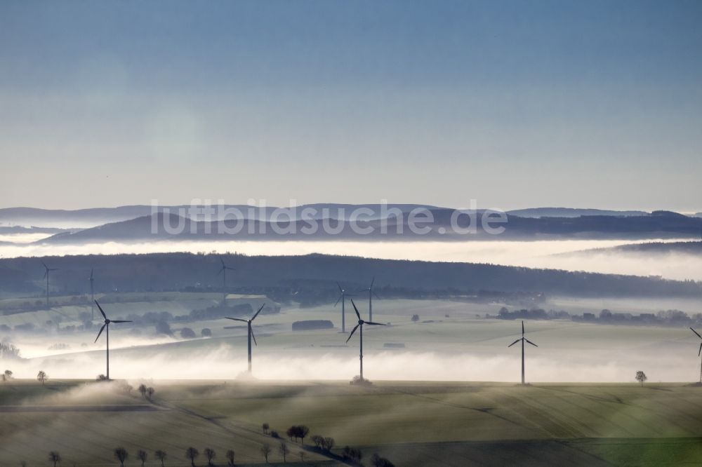 Ense von oben - Windräder eines aus Nebel- Schicht und Wolken herausragenden Windkraftwerkes bei Ense im Sauerland in Nordrhein-Westfalen NRW