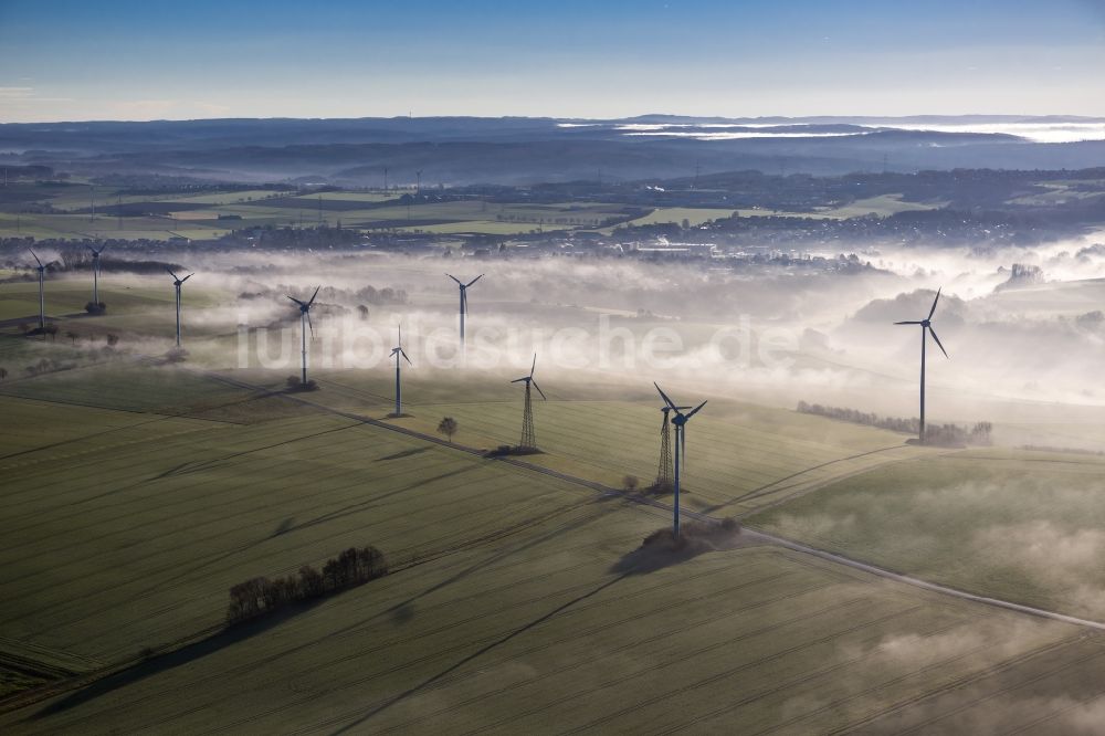 Ense aus der Vogelperspektive: Windräder eines aus Nebel- Schicht und Wolken herausragenden Windkraftwerkes bei Ense im Sauerland in Nordrhein-Westfalen NRW