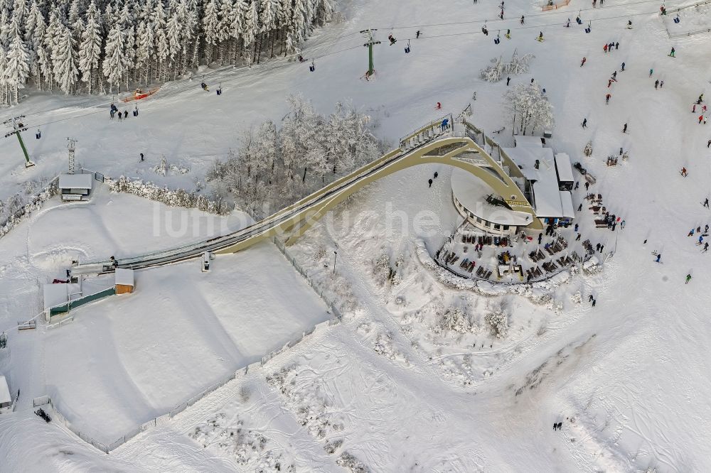 Luftaufnahme Winterberg - Winter - Blick auf die mit Schnee bedeckte Sprungschanze St.Georg - Schanze und der Apres-Ski - Raststätte in Winterberg im Bundesland Nordrhein-Westfalen NRW