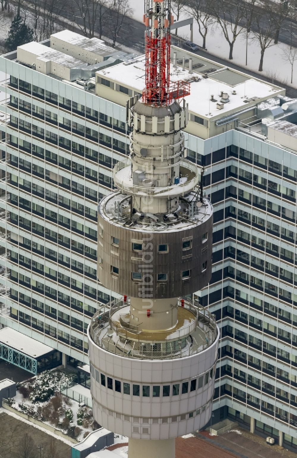 Dortmund aus der Vogelperspektive: Winter - Luftbild des schneebedeckten Gebäudes des Fernsehturm mit dem RWE- Hochhaus in Dortmund im Bundesland Nordrhein-Westfalen