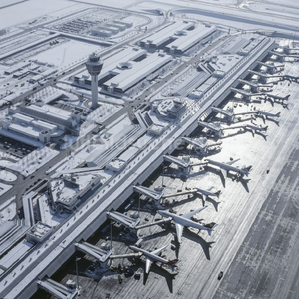 München-Flughafen aus der Vogelperspektive: Winterlich mit Schnee bedeckte Rollwege, Start- und Landebahnen am Flughafen München in Bayern