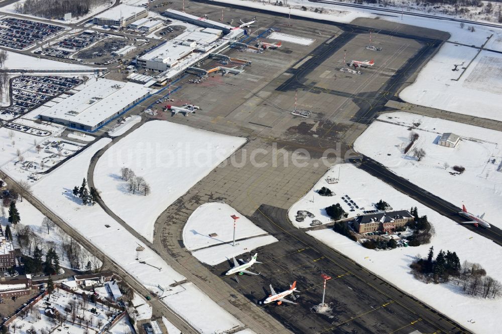 Schönefeld von oben - Winterlich mit Schnee bedecktes Rollfeld , Rollwege , Abfertigungshalle und altes DDR- Terminal aus INTERFLUG Zeiten am Flughafen Berlin - Schönefeld