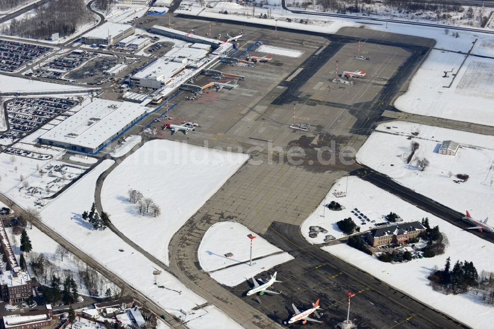 Luftbild Schönefeld - Winterlich mit Schnee bedecktes Rollfeld , Rollwege , Abfertigungshalle und altes DDR- Terminal aus INTERFLUG Zeiten am Flughafen Berlin - Schönefeld