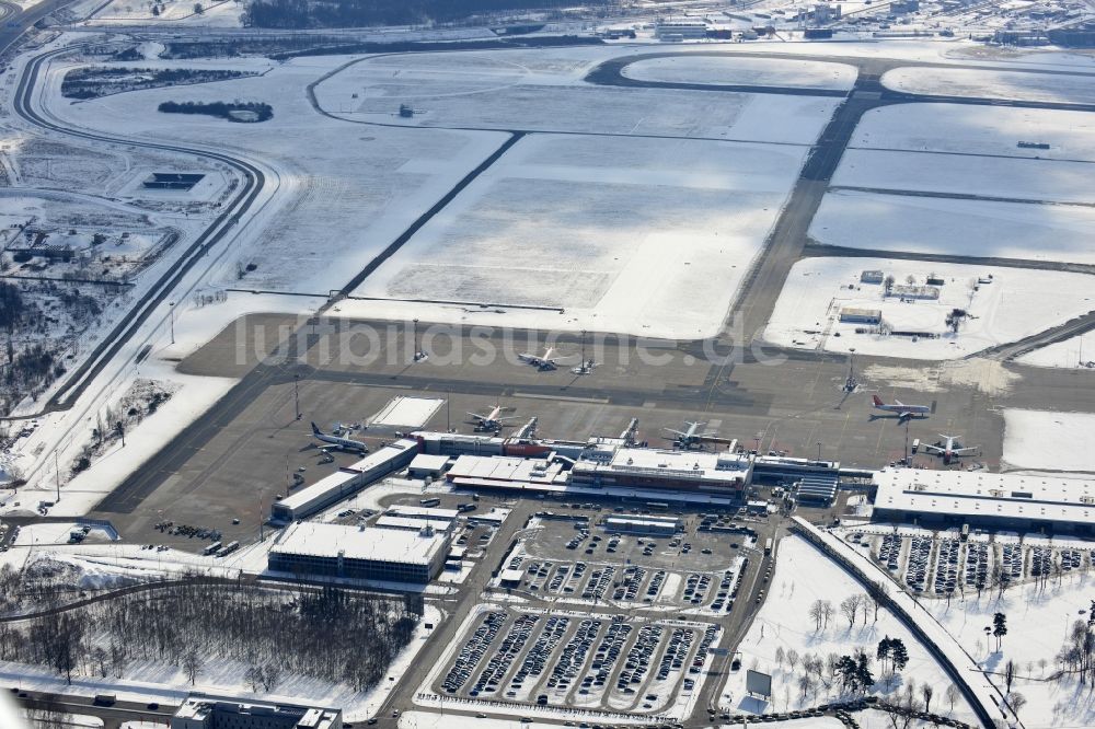 Luftaufnahme Schönefeld - Winterlich mit Schnee bedecktes Rollfeld , Rollwege , Abfertigungshalle und altes DDR- Terminal aus INTERFLUG Zeiten am Flughafen Berlin - Schönefeld