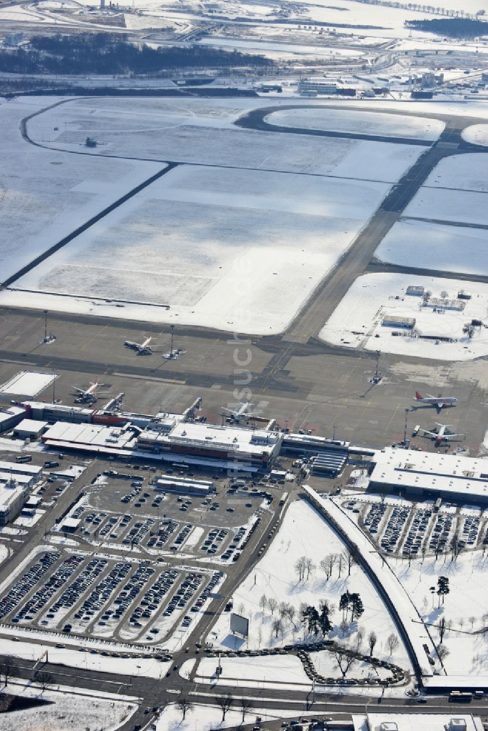 Schönefeld von oben - Winterlich mit Schnee bedecktes Rollfeld , Rollwege , Abfertigungshalle und altes DDR- Terminal aus INTERFLUG Zeiten am Flughafen Berlin - Schönefeld