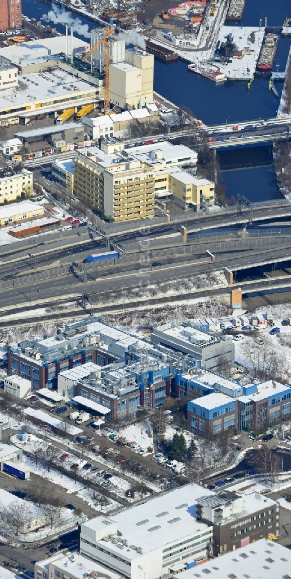 Luftaufnahme Berlin Neukölln - Winterlich mit Schnee bedecktes Werksgelände der BIOTRONIK SE & Co. KG an der Woermannkehre in Berlin Neukölln