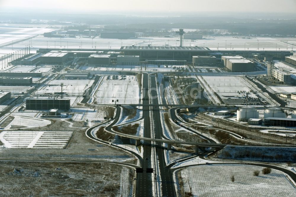 Schönefeld aus der Vogelperspektive: Winterlich schneebedeckte Abfertigungs- Gebäude und Terminals auf dem Gelände des Flughafen in Schönefeld im Bundesland Brandenburg