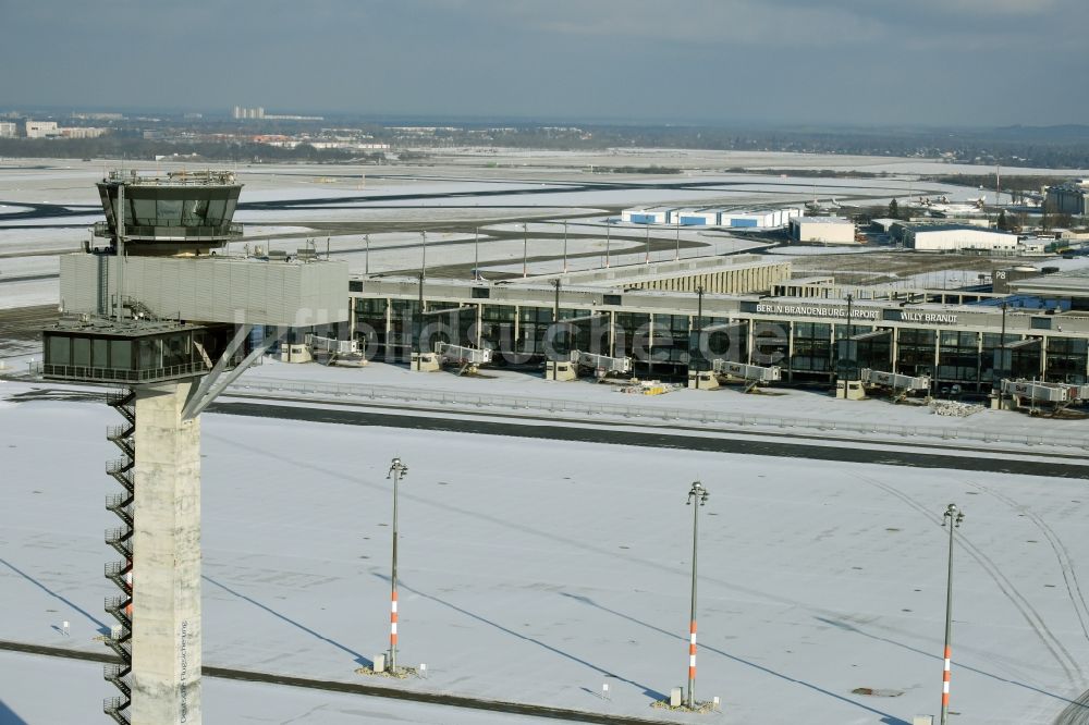 Luftaufnahme Schönefeld - Winterlich schneebedeckte Abfertigungs- Gebäude und Terminals auf dem Gelände des Flughafen in Schönefeld im Bundesland Brandenburg