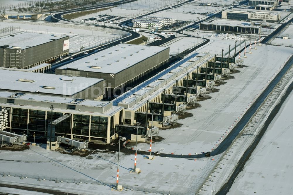 Schönefeld von oben - Winterlich schneebedeckte Abfertigungs- Gebäude und Terminals auf dem Gelände des Flughafen in Schönefeld im Bundesland Brandenburg