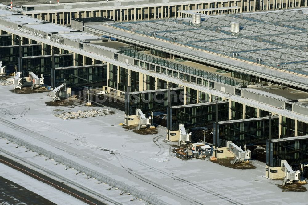 Luftbild Schönefeld - Winterlich schneebedeckte Abfertigungs- Gebäude und Terminals auf dem Gelände des Flughafen in Schönefeld im Bundesland Brandenburg