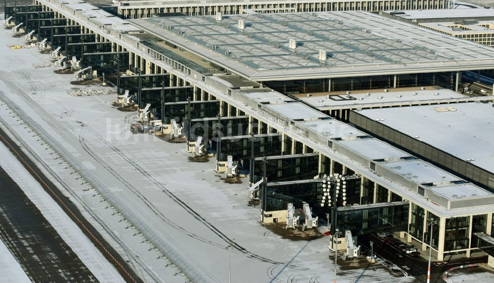 Schönefeld von oben - Winterlich schneebedeckte Abfertigungs- Gebäude und Terminals auf dem Gelände des Flughafen in Schönefeld im Bundesland Brandenburg