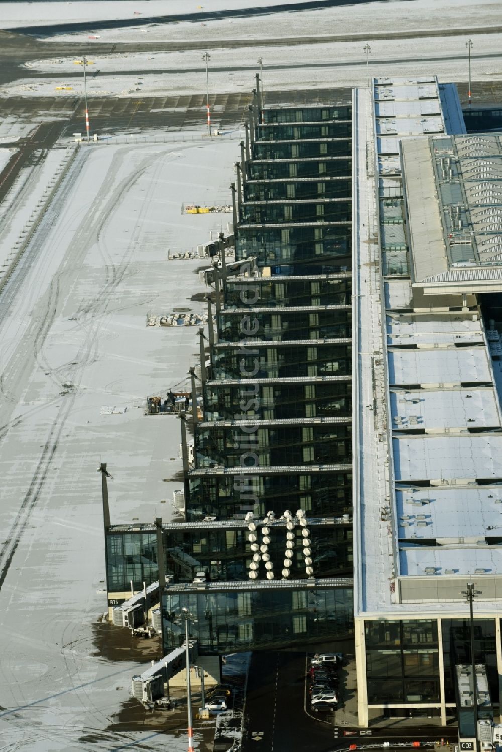 Schönefeld von oben - Winterlich schneebedeckte Abfertigungs- Gebäude und Terminals auf dem Gelände des Flughafen in Schönefeld im Bundesland Brandenburg