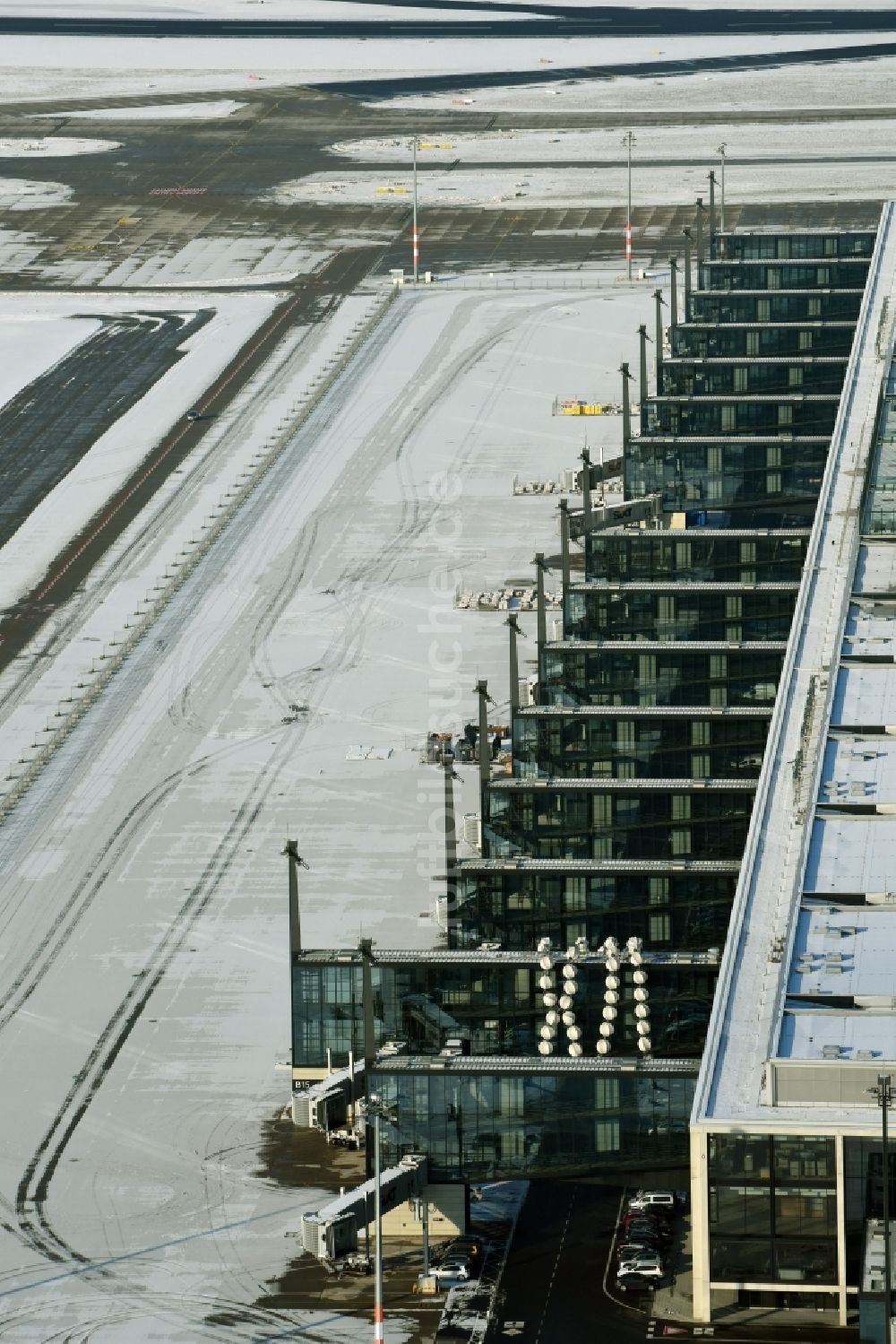 Luftbild Schönefeld - Winterlich schneebedeckte Abfertigungs- Gebäude und Terminals auf dem Gelände des Flughafen in Schönefeld im Bundesland Brandenburg