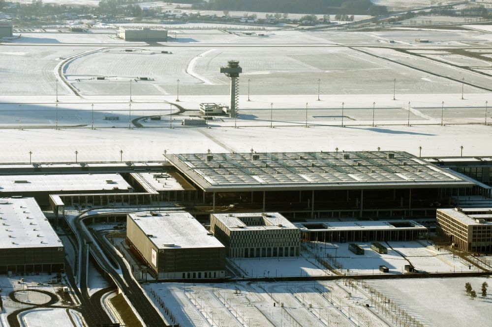 Schönefeld aus der Vogelperspektive: Winterlich schneebedeckte Abfertigungs- Gebäude und Terminals auf dem Gelände des Flughafen in Schönefeld im Bundesland Brandenburg