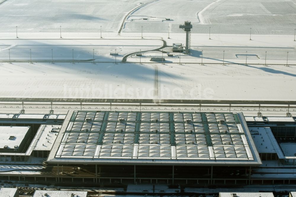 Luftbild Schönefeld - Winterlich schneebedeckte Abfertigungs- Gebäude und Terminals auf dem Gelände des Flughafen in Schönefeld im Bundesland Brandenburg