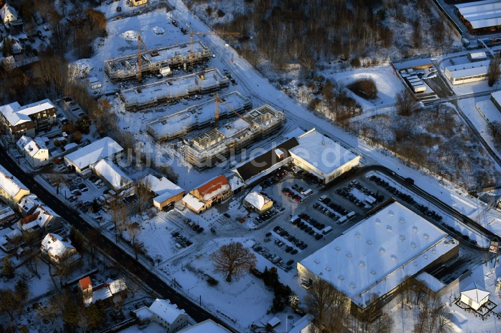 Luftaufnahme Berlin - Winterlich schneebedeckte Baustelle zum Neubau einer Mehrfamilienhaus-Wohnanlage An der Schule im Stadtteil Mahlsdorf in Berlin