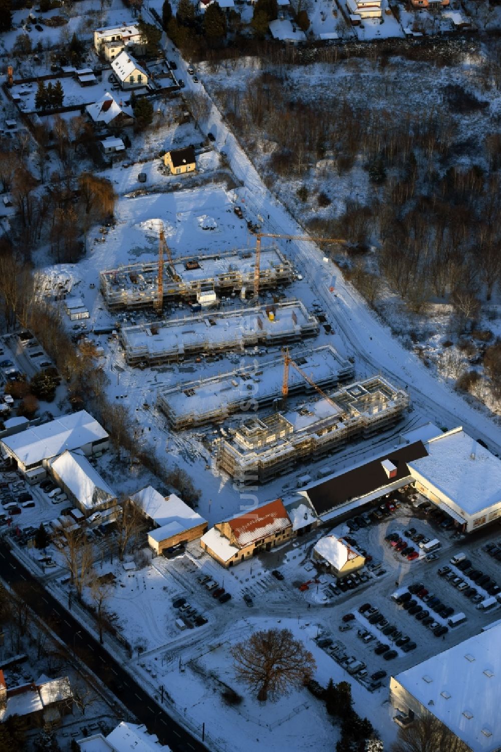 Berlin von oben - Winterlich schneebedeckte Baustelle zum Neubau einer Mehrfamilienhaus-Wohnanlage An der Schule im Stadtteil Mahlsdorf in Berlin