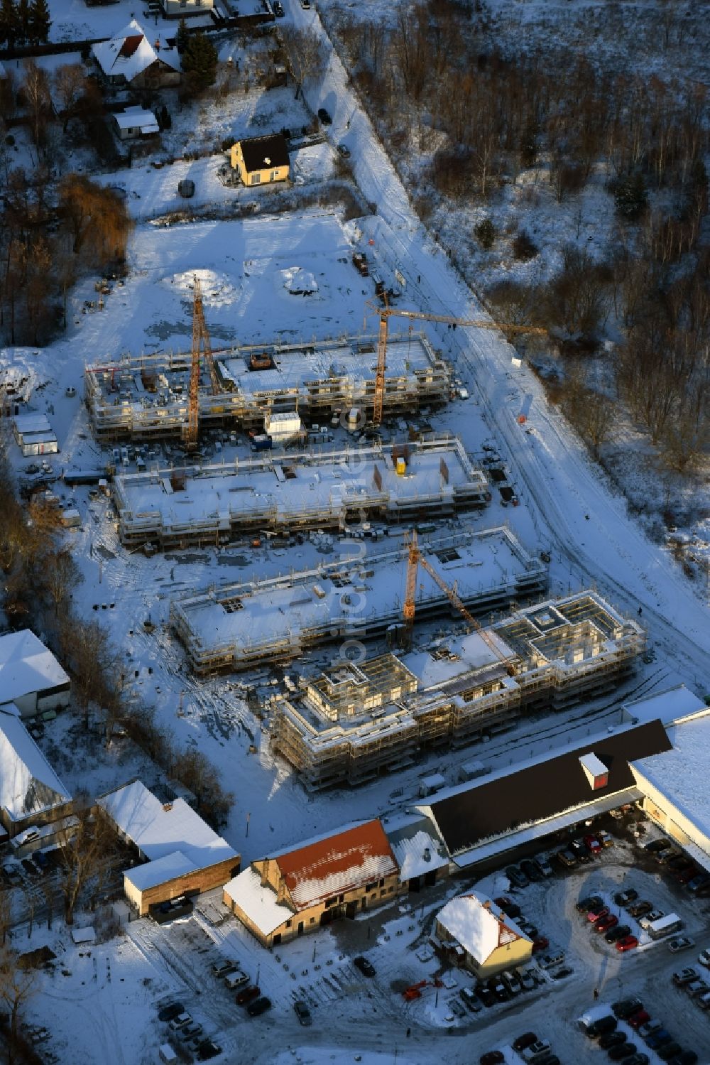 Berlin aus der Vogelperspektive: Winterlich schneebedeckte Baustelle zum Neubau einer Mehrfamilienhaus-Wohnanlage An der Schule im Stadtteil Mahlsdorf in Berlin