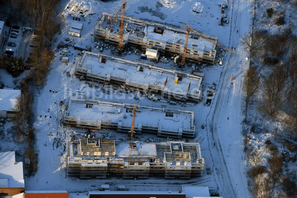 Luftbild Berlin - Winterlich schneebedeckte Baustelle zum Neubau einer Mehrfamilienhaus-Wohnanlage An der Schule im Stadtteil Mahlsdorf in Berlin