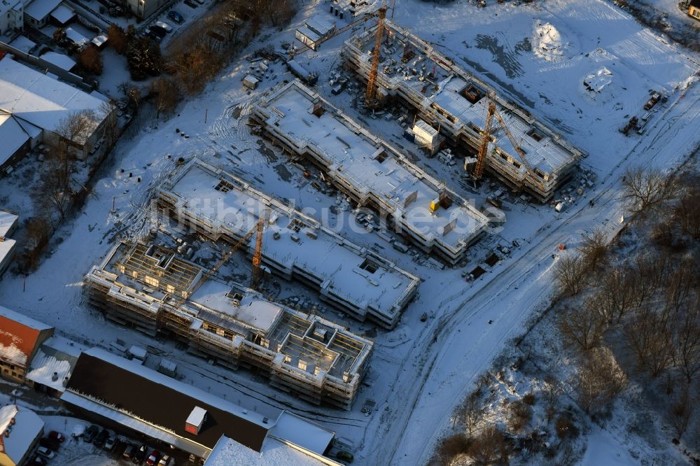 Berlin von oben - Winterlich schneebedeckte Baustelle zum Neubau einer Mehrfamilienhaus-Wohnanlage An der Schule im Stadtteil Mahlsdorf in Berlin