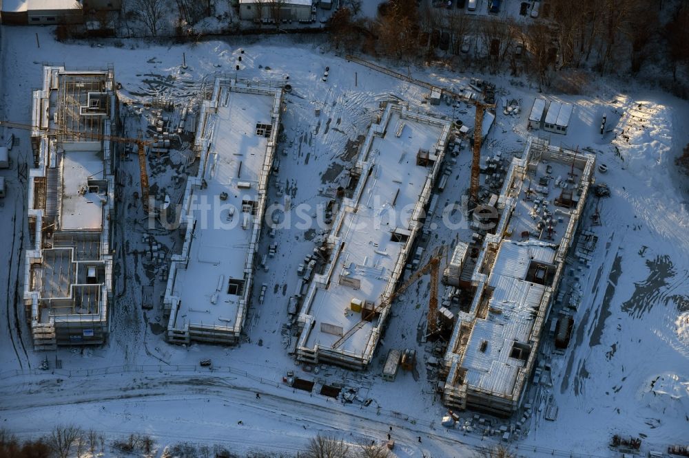 Berlin von oben - Winterlich schneebedeckte Baustelle zum Neubau einer Mehrfamilienhaus-Wohnanlage An der Schule im Stadtteil Mahlsdorf in Berlin