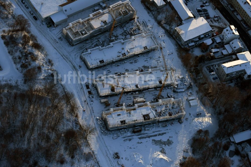 Berlin aus der Vogelperspektive: Winterlich schneebedeckte Baustelle zum Neubau einer Mehrfamilienhaus-Wohnanlage An der Schule im Stadtteil Mahlsdorf in Berlin