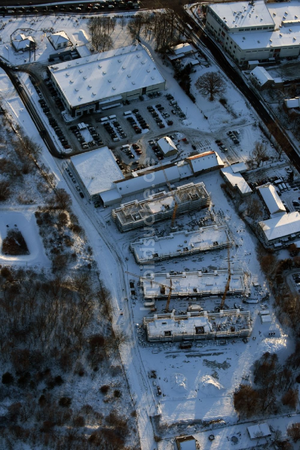 Luftbild Berlin - Winterlich schneebedeckte Baustelle zum Neubau einer Mehrfamilienhaus-Wohnanlage An der Schule im Stadtteil Mahlsdorf in Berlin