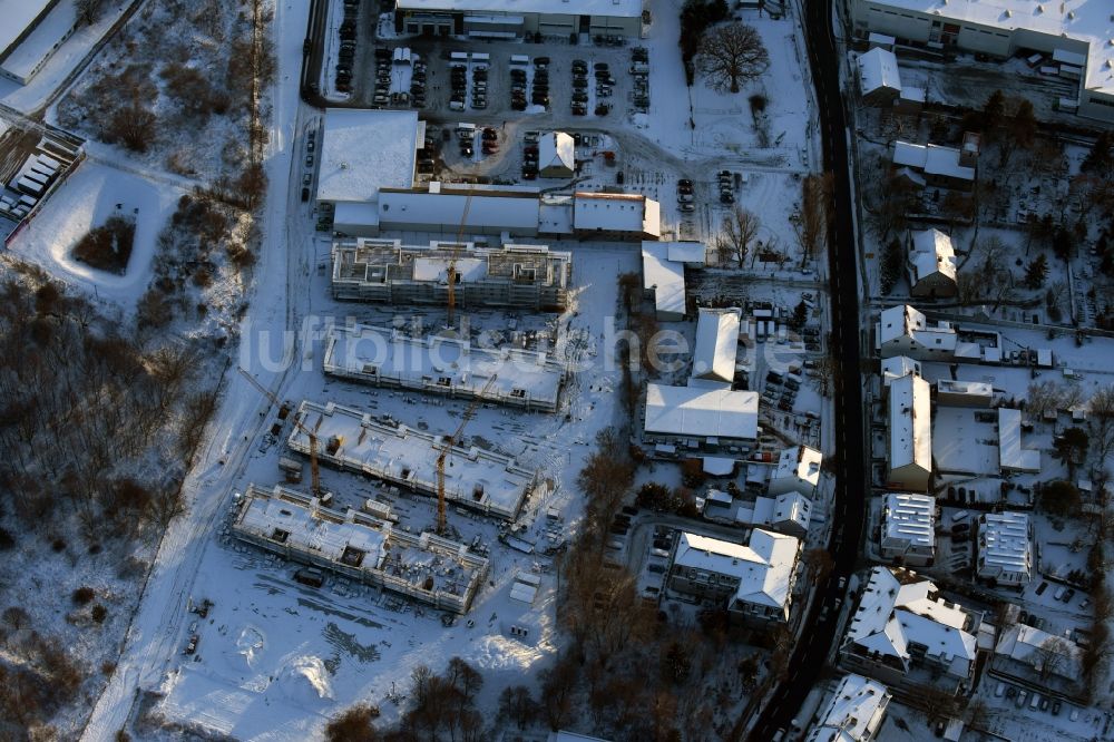 Berlin von oben - Winterlich schneebedeckte Baustelle zum Neubau einer Mehrfamilienhaus-Wohnanlage An der Schule im Stadtteil Mahlsdorf in Berlin