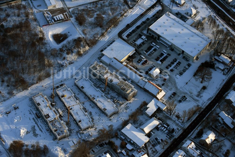 Luftbild Berlin - Winterlich schneebedeckte Baustelle zum Neubau einer Mehrfamilienhaus-Wohnanlage An der Schule im Stadtteil Mahlsdorf in Berlin