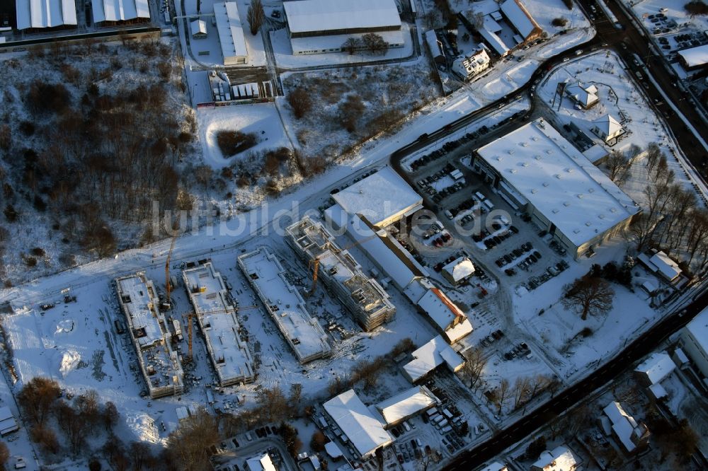 Luftaufnahme Berlin - Winterlich schneebedeckte Baustelle zum Neubau einer Mehrfamilienhaus-Wohnanlage An der Schule im Stadtteil Mahlsdorf in Berlin